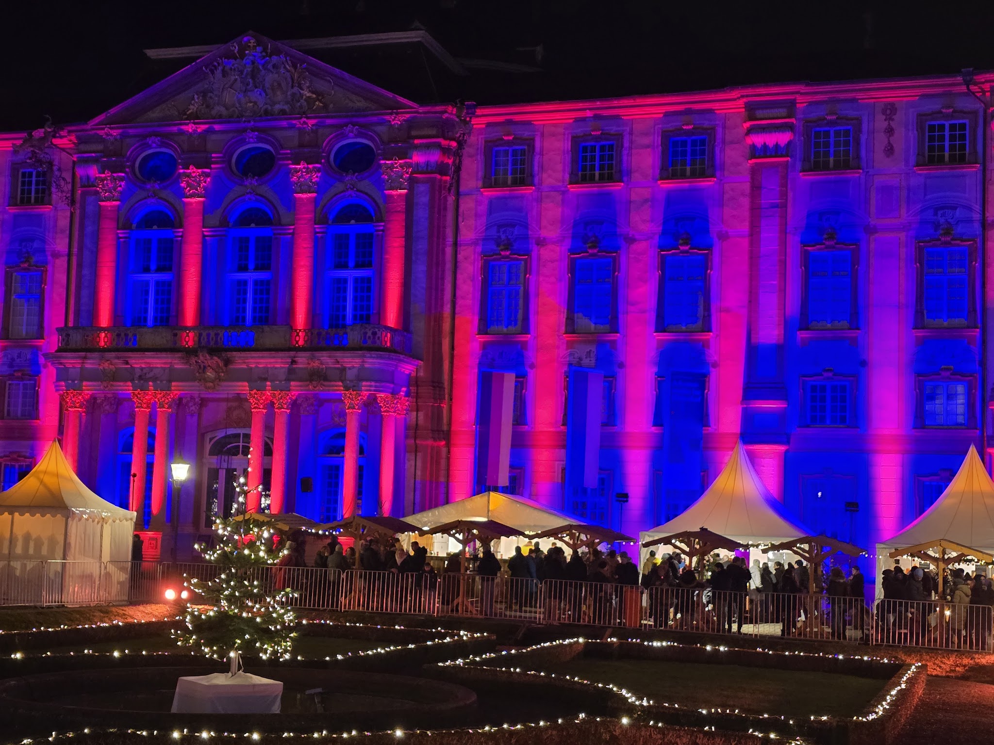 Die Bruchsaler Schlossweihnacht: beleuchtetes Barockschloss über den Ständen